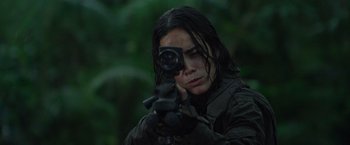 Movie still from “Predators” (2010), directed by Nimród Antal – A woman is holding a rifle and aiming it; Close Up shot, Low angle