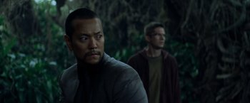 Movie still from “Predators” (2010), directed by Nimród Antal – Two men standing next to each other near a forest; Close Up shot, Over the shoulder angle