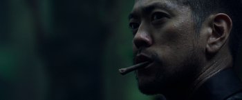 Movie still from “Predators” (2010), directed by Nimród Antal – A person with a cigarette in his mouth; Close Up shot, Low angle