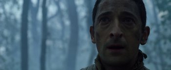 Movie still from “Predators” (2010), directed by Nimród Antal – A man's face in front of trees; Close Up shot, Low angle