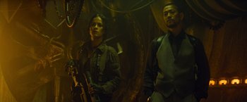 Movie still from “Predators” (2010), directed by Nimród Antal – A man and a woman holding guns in a dark room; Medium shot, Low angle