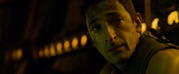 Movie still from “Predators” (2010), directed by Nimród Antal – A man's face in the dark; Close Up shot, Low angle