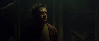 Movie still from “Predators” (2010), directed by Nimród Antal – A man in a dark room with his head turned to the side; Close Up shot, Low angle