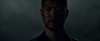 Movie still from “Predators” (2010), directed by Nimród Antal – A person wearing a black shirt; Close Up shot, Low angle