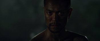 Movie still from “Predators” (2010), directed by Nimród Antal – A man's face in the dark; Close Up shot, Low angle