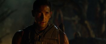 Movie still from “Predators” (2010), directed by Nimród Antal – A person wearing a leather vest; Close Up shot, Over the shoulder angle