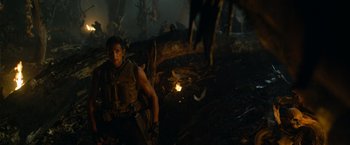 Movie still from “Predators” (2010), directed by Nimród Antal – A man standing next to an animal in a forest; Medium shot, Low angle