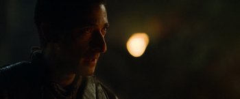 Movie still from “Predators” (2010), directed by Nimród Antal – A man's face in the dark; Close Up shot, Over the shoulder angle