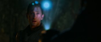 Movie still from “Predators” (2010), directed by Nimród Antal – A person in a dark room; Close Up shot, Over the shoulder angle