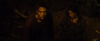 Movie still from “Predators” (2010), directed by Nimród Antal – A man and a woman standing next to each other in the dark; Medium shot, High angle