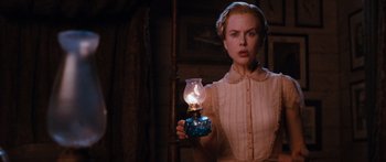 Movie still from “Australia” (2008), directed by Baz Luhrmann – A woman holding an oil lamp in a dimly - lit room; Close Up shot, Low angle