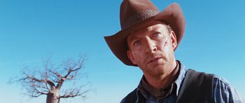 Movie still from “Australia” (2008), directed by Baz Luhrmann – A man wearing a cowboy hat in front of a tree; Close Up shot, Low angle