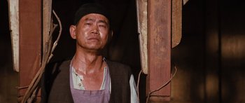 Movie still from “Australia” (2008), directed by Baz Luhrmann – An older man wearing an apron and a black hat; Close Up shot, Low angle