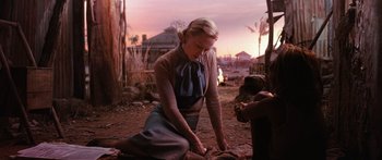 Movie still from “Australia” (2008), directed by Baz Luhrmann – A woman kneeling on the ground in front of a tree; Medium shot, Over the shoulder angle