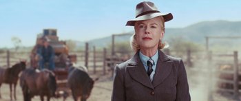Movie still from “Australia” (2008), directed by Baz Luhrmann – A woman wearing a suit and a hat standing in front of a cow; Close Up shot, Low angle