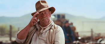 Movie still from “Australia” (2008), directed by Baz Luhrmann – An older man wearing a tan hat and holding his hand up to his forehead; Close Up shot, Low angle
