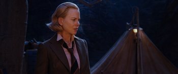 Movie still from “Australia” (2008), directed by Baz Luhrmann – A woman wearing a suit and tie standing in front of a tent; Close Up shot, Over the shoulder angle