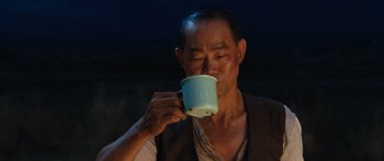 Movie still from “Australia” (2008), directed by Baz Luhrmann – An older man is drinking a cup of coffee; Close Up shot, Over the shoulder angle