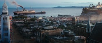Movie still from “Australia” (2008), directed by Baz Luhrmann – An aerial view of a city with a ship in the background; Extreme Wide shot, High angle