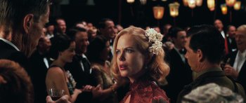 Movie still from “Australia” (2008), directed by Baz Luhrmann – A woman with a flower in her hair in front of a group of people; Close Up shot, Over the shoulder angle
