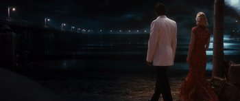 Movie still from “Australia” (2008), directed by Baz Luhrmann – A man in a white jacket is walking on the beach at night; Wide shot, Over the shoulder angle