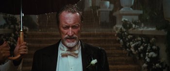 Movie still from “Australia” (2008), directed by Baz Luhrmann – An older man in a tuxedo holding an umbrella; Close Up shot, Low angle