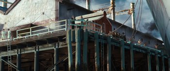 Movie still from “Australia” (2008), directed by Baz Luhrmann – Two men standing on a pier next to a building; Extreme Wide shot, Low angle