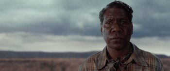 Movie still from “Australia” (2008), directed by Baz Luhrmann – An older man in a plaid shirt is looking at the camera; Close Up shot, Low angle