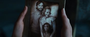 Movie still from “Australia” (2008), directed by Baz Luhrmann – A person holding a picture of a man and a woman and a little girl; Extreme Close Up shot, Overhead angle