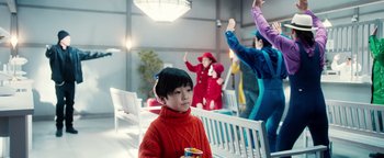 Movie still from “Prisoners of the Ghostland” (2021), directed by Sion Sono – A group of people standing in a room; Medium shot, Over the shoulder angle