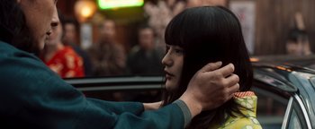 Movie still from “Prisoners of the Ghostland” (2021), directed by Sion Sono – A woman getting her hair combed by a man; Close Up shot, Over the shoulder angle