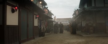 Movie still from “Prisoners of the Ghostland” (2021), directed by Sion Sono – A group of people walking down a street; Extreme Wide shot, Low angle