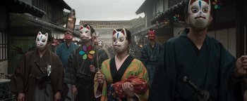 Movie still from “Prisoners of the Ghostland” (2021), directed by Sion Sono – A group of people wearing masks in the street; Medium shot, Low angle