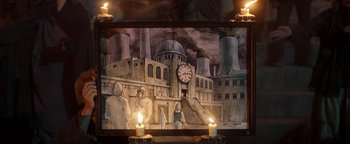 Movie still from “Prisoners of the Ghostland” (2021), directed by Sion Sono – An oil painting of a clock tower in the middle of a city; Extreme Wide shot, High angle