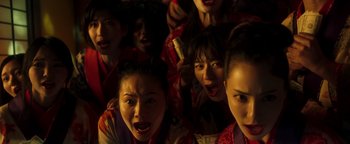 Movie still from “Prisoners of the Ghostland” (2021), directed by Sion Sono – A group of women in red and white outfits; Extreme Close Up shot, High angle