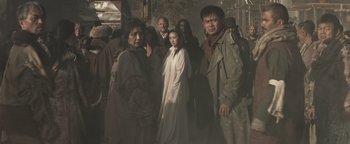 Movie still from “Prisoners of the Ghostland” (2021), directed by Sion Sono – A group of people standing next to each other; Wide shot, Low angle