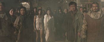 Movie still from “Prisoners of the Ghostland” (2021), directed by Sion Sono – A group of people standing in the middle of a street; Wide shot, Low angle