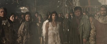 Movie still from “Prisoners of the Ghostland” (2021), directed by Sion Sono – A group of people are walking in a line; Medium shot, Low angle