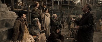 Movie still from “Prisoners of the Ghostland” (2021), directed by Sion Sono – A group of people dressed in old clothes; Wide shot, High angle