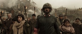 Movie still from “Prisoners of the Ghostland” (2021), directed by Sion Sono – A group of people walking down a street; Medium shot, Low angle
