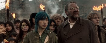 Movie still from “Prisoners of the Ghostland” (2021), directed by Sion Sono – A group of people standing next to each other; Medium shot, Low angle