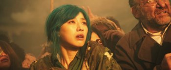 Movie still from “Prisoners of the Ghostland” (2021), directed by Sion Sono – A woman with green hair looking up at the sky; Close Up shot, Low angle