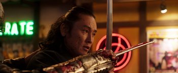 Movie still from “Prisoners of the Ghostland” (2021), directed by Sion Sono – A man holding a sword with blood all over his face; Close Up shot, Low angle
