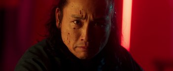 Movie still from “Prisoners of the Ghostland” (2021), directed by Sion Sono – A person wearing a black jacket; Close Up shot, Low angle