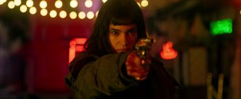 Movie still from “Prisoners of the Ghostland” (2021), directed by Sion Sono – A woman is holding a gun in her hand; Close Up shot, Low angle