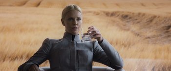 Movie still from “Prometheus” (2012), directed by Ridley Scott – A woman holding a glass of water while wearing a suit; Close Up shot, Low angle