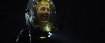Movie still from “Prometheus” (2012), directed by Ridley Scott – A woman wearing a space suit and a helmet; Close Up shot, Low angle