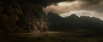Movie still from “Prometheus” (2012), directed by Ridley Scott – A large amount of smoke billows from a mountain; Extreme Wide shot, High angle