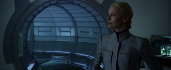 Movie still from “Prometheus” (2012), directed by Ridley Scott – A woman standing in front of a wall in a room; Medium shot, Over the shoulder angle