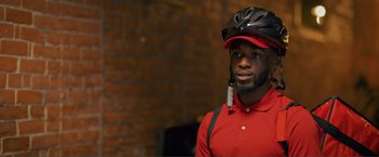 Movie still from “Puppy Love” (2023), directed by Richard Alan Reid – A man wearing a red shirt and a helmet; Close Up shot, Over the shoulder angle